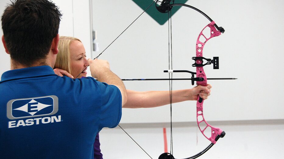 A person learning to use a compound bow at an archery pro shop in Oklahoma City, OK