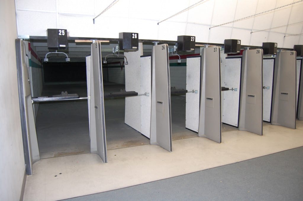Indoor shooting range with numbered lanes, partitions, and target carriers at H&H Shooting Sports
