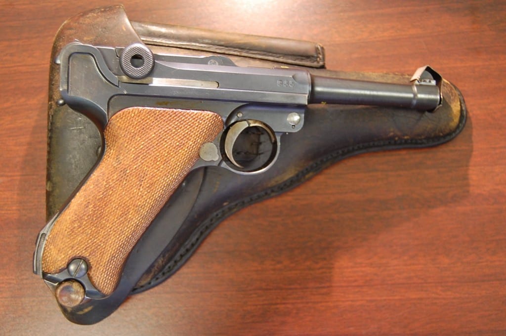 Vintage semi-automatic pistol with a textured wooden grip and dark metal finish at H&H Shooting Sports

