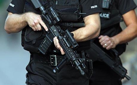 Armed police officers in tactical gear holding rifles in H&H Shooting Sports